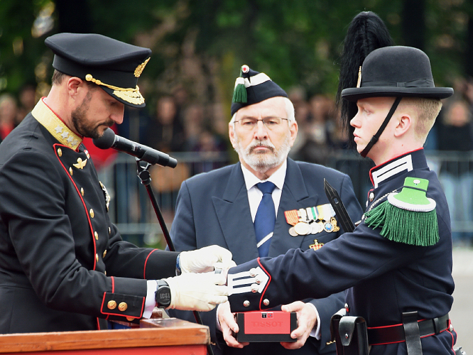 Kronprins Haakon fester Gardens Ur rundt hånden til gardist Jørgen Lauritzen. Foto: Sven Gj. Gjeruldsen, Det kongelige hoff